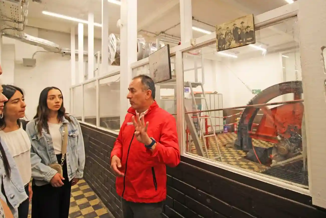 Guía de Turistik explicando la sala de maquinaria histórica del Funicular Santiago a visitantes