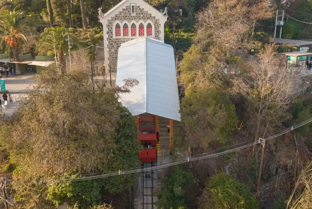 Vista aérea de la estación del Funicular Santiago con el carro rojo en el andén y el edificio patrimonial al fondo