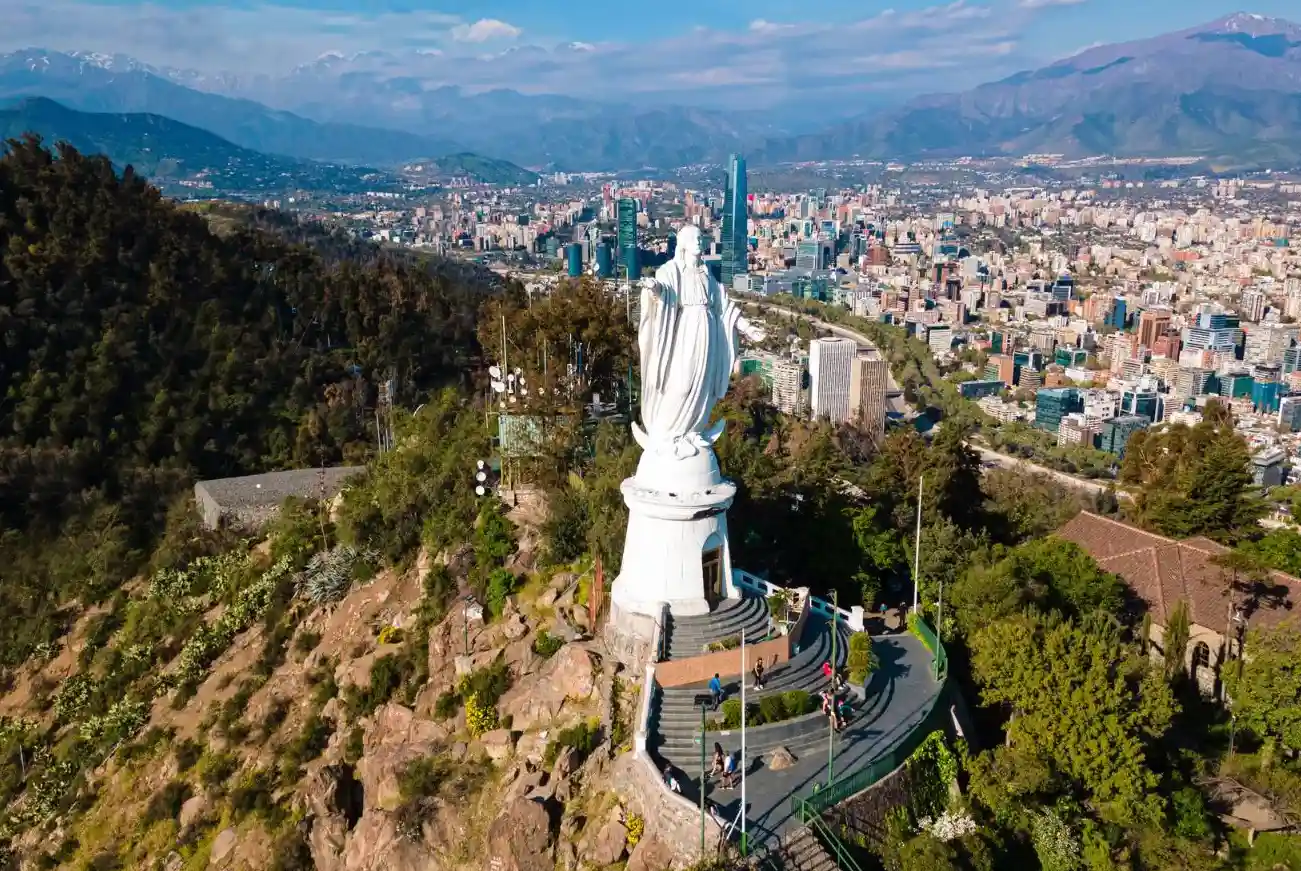 Vista aérea de la Virgen del Cerro San Cristóbal con el skyline de Santiago y la cordillera de los Andes al fondo