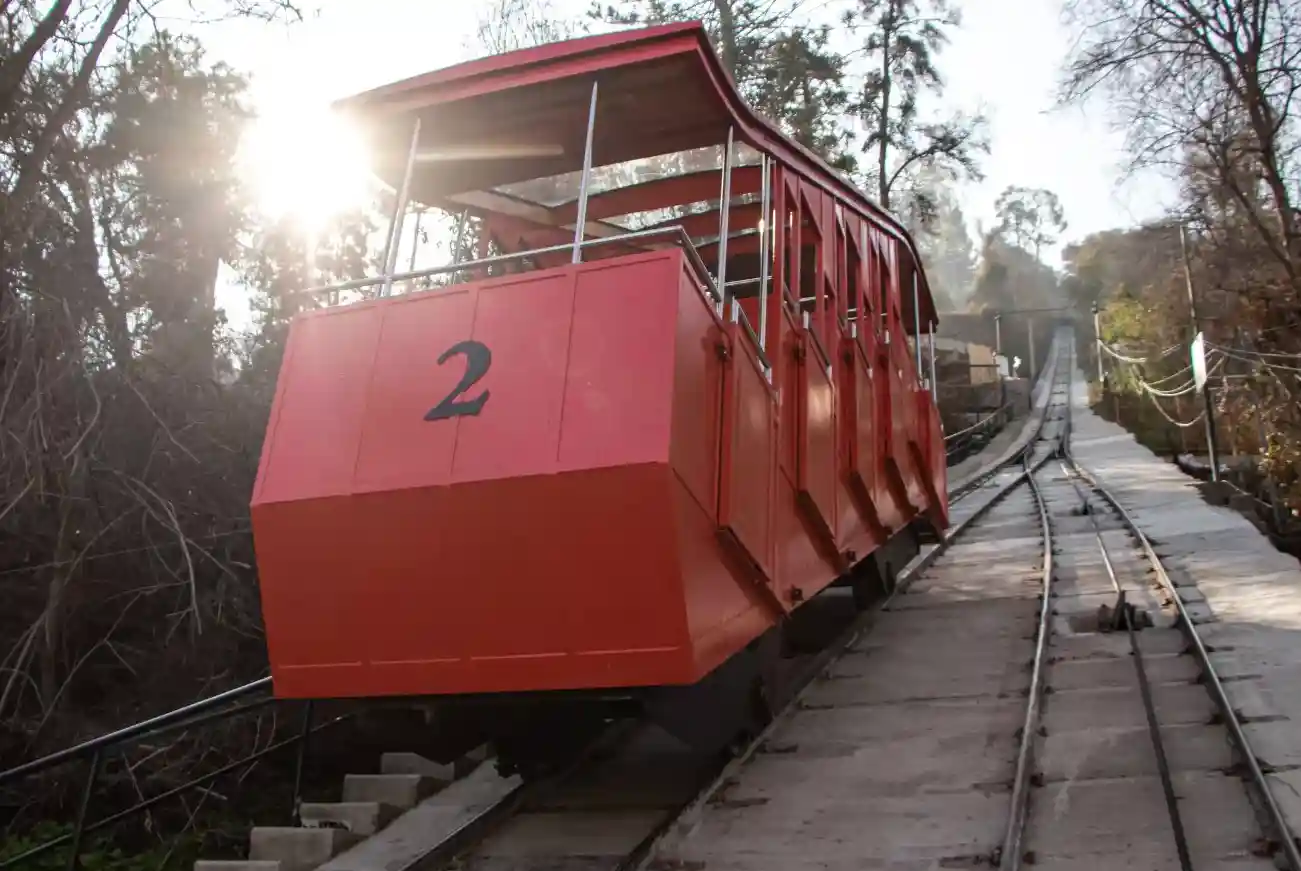 Carro número 2 del Funicular Santiago sobre las vías entre árboles del Parque Metropolitano